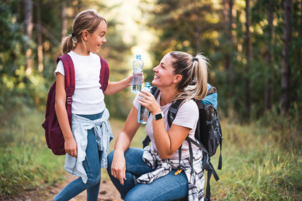istock Mother and daughter drinking water while  hiking 1422202038