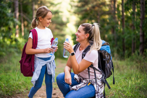 istock Mother and daughter drinking water while  hiking 1422202066