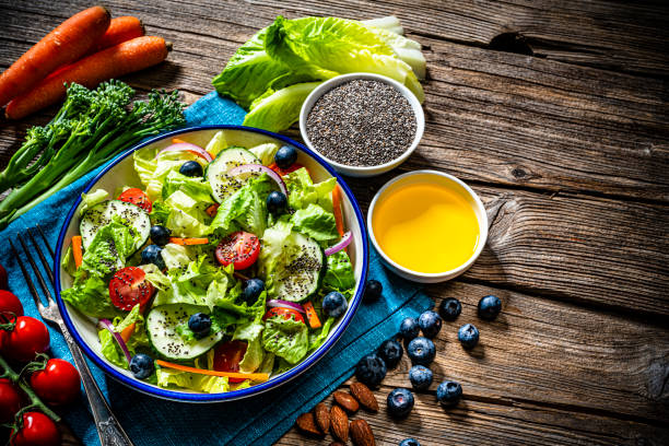 健康サラダ、チアシード、オリーブオイルを素朴なテーブルの上に上から撃った - ingredient broccoli cherry tomato carrot ストックフォトと画像