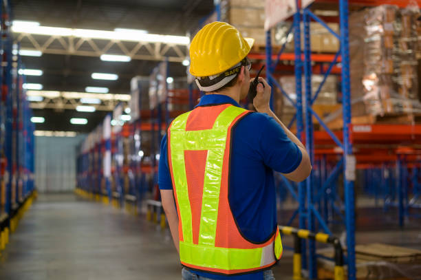 istock Young asian male worker wearing helmet using talki walki in modern warehouse. 1422207985