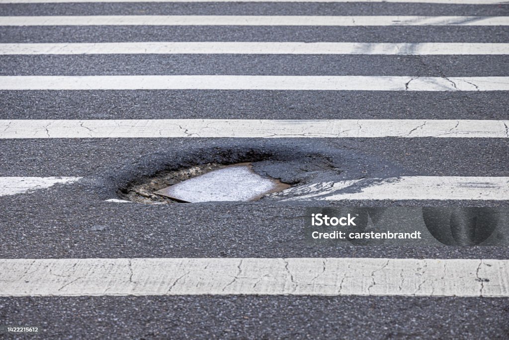 Pot hole in a zebra crossing Pot holes in zebra crossings are common in the middle of Manhattan this one is found on Broadway High Angle View Stock Photo