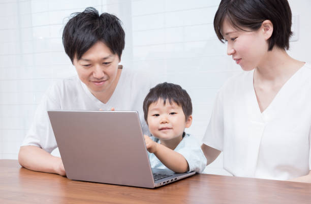 istock Japanese family making a travel reservation on a computer 1422219586