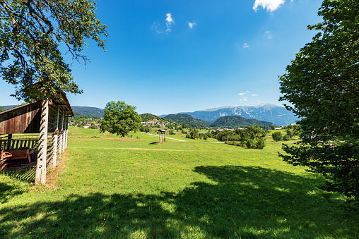 Appenzell, Switzerland - June 26, 2021: Some lovely cows sitting in the grass, two chalets and mountain Hoher Kasten in the background. The Alpstein region is well known in the Appenzellerland for hiking tours.