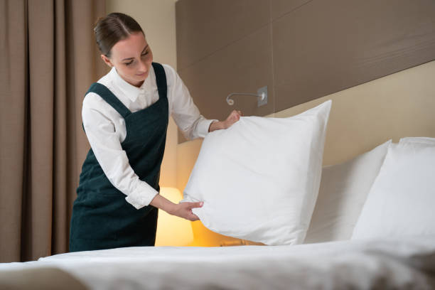 istock Female worker makes bed changing linen and folding pillows 1422222992