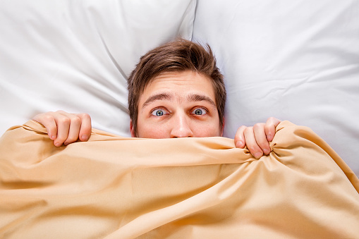 Worried Young Man under Blanket in the Bed at the Home