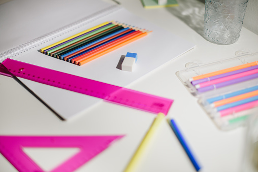 School supplies with rulers, crayons and markers and some white paper