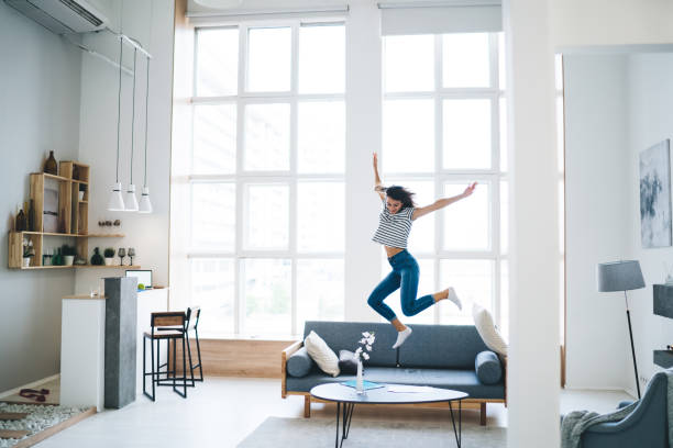 Expressive young lady celebrating success at home