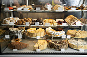 istock Pastry shop glass display with selection of cream or fruit cake, bakery shop with various flavors of cake 1422237324