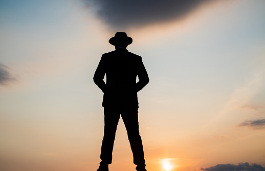 business success. freedom. personal achievement goal. man silhouette on sky background. confident businessman silhouette. daily motivation. enjoying life and nature. perfect sunset.