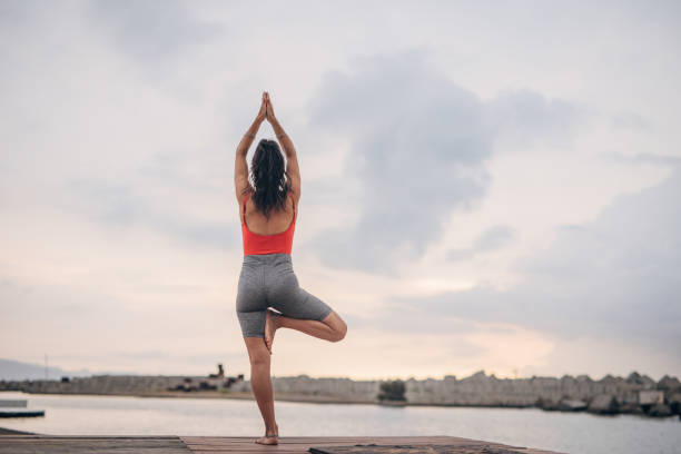 istock Woman training yoga on the beach 1422238649