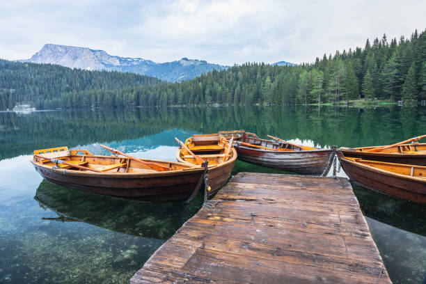 Black lake with boats on mount Durmitor, Montenegro Black lake with boatd on mount Durmitor, Montenegro, glacier lake durmitor national park photos stock pictures, royalty-free photos & images