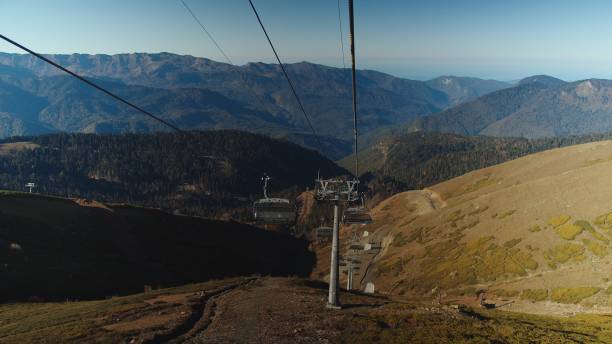 istock Exciting view on caucasian mountain range from cable car moving down. Travelling by cable road among the incredible beaty of mountains on sunny autumn day. 1422250515