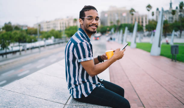 istock Positive young ethnic hipster using smartphone on street 1422253099
