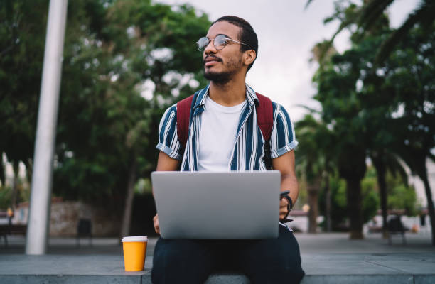 istock Focused young man with laptop working remotely in park 1422253118
