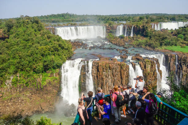 turistas em plataforma no mirante do rio iguaçu, nas cataratas do iguaçu, brasil. - iguacu national park - fotografias e filmes do acervo