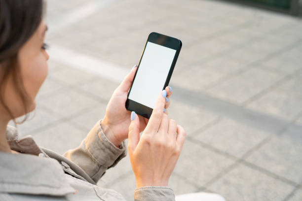 istock Woman using smartphone with a blank screen outdoors 1422264338