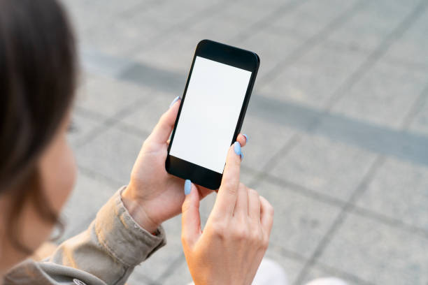 istock Woman using smartphone with a blank screen outdoors 1422264344