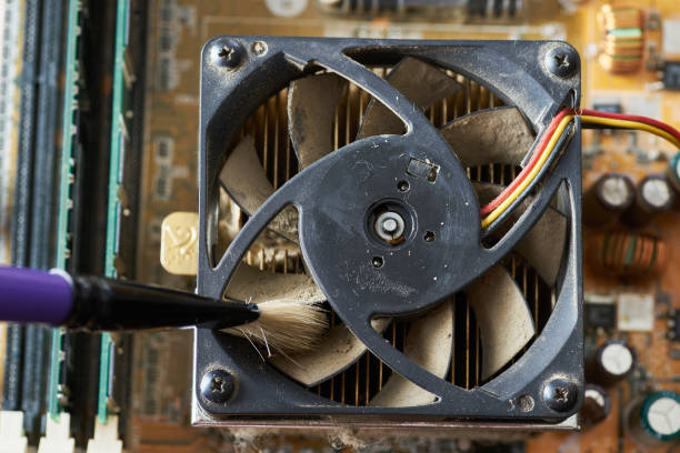 istock Cleaning dirty desktop computer processor fan from dust by special brush close up. 1422264968