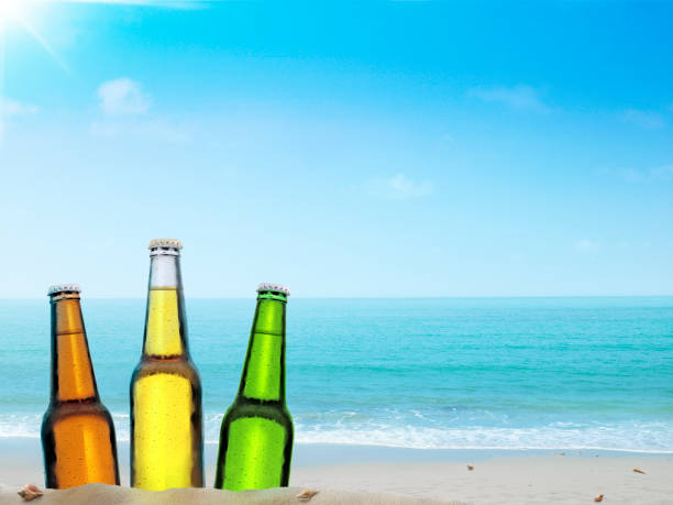 istock Bottle of beer on a sandy beach with clear sky 1422266243