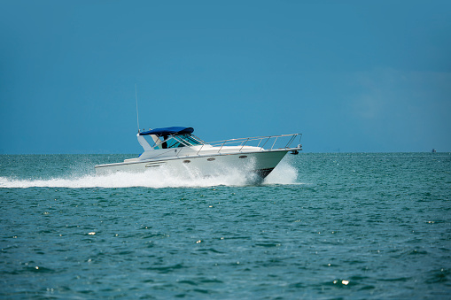 new powerboat speeding towards camera with blue sky