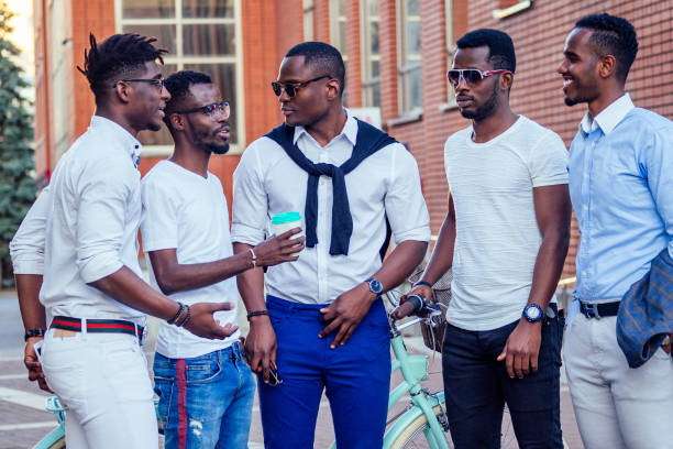 a group of five handsome African American friends of the groom fashionable well-dressed businessmen having fun and rest and enjoy in the summer in the park stock photo