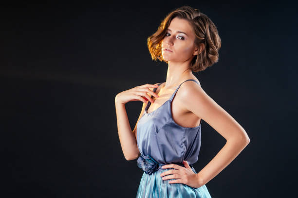 portrait of a young woman in windy blue dress. Beautiful girl with creative make-up and short haircut hairstyle portrait of a young woman in windy blue dress. Beautiful girl with creative make-up and short haircut hairstyle uk free bets stock pictures, royalty-free photos & images