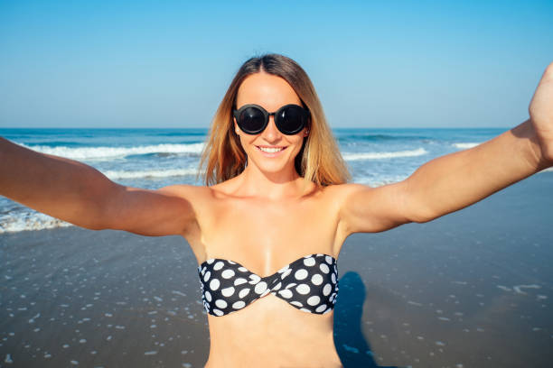 istock smiling and beautiful woman doing selfie on vacation 1422271371