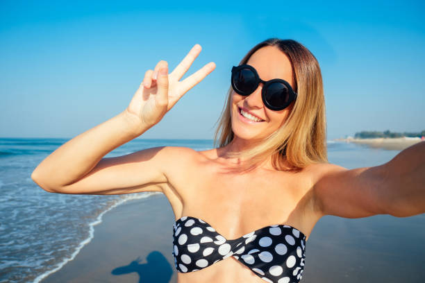 istock smiling and beautiful woman doing selfie on vacation 1422271380