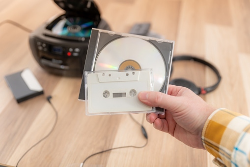 Holding a CD and cassette tape