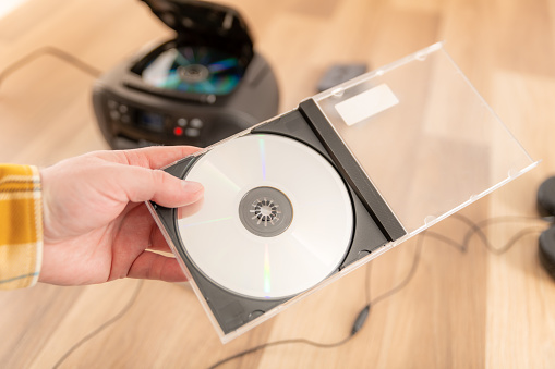 Holding a Compact Disc (CD) in a plastic case with copyspace