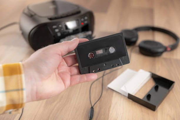 istock Holding a black cassette tape, retro audio equipment 1422272935