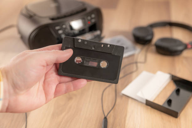 istock Holding a black cassette tape, retro audio equipment 1422272936