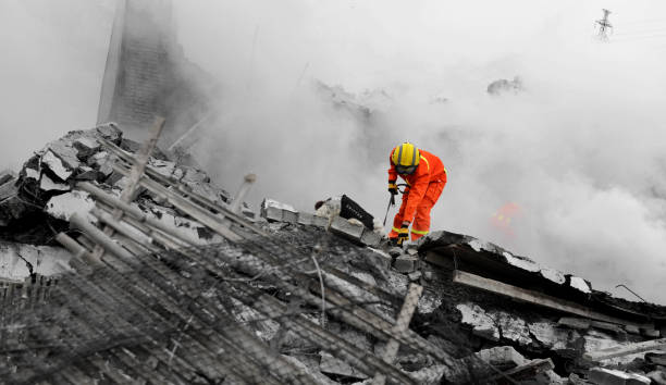 les forces de recherche et de sauvetage fouillent dans un bâtiment détruit - rescue worker photos et images de collection