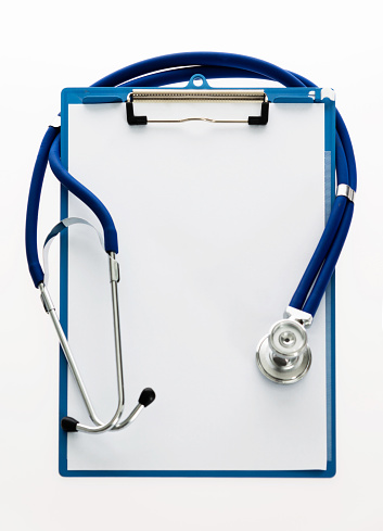 Stethoscope and clipboard on white background