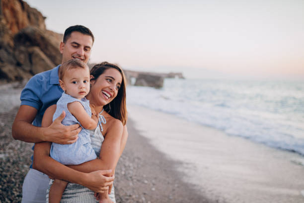 istock Family holding hands on beach 1422279742