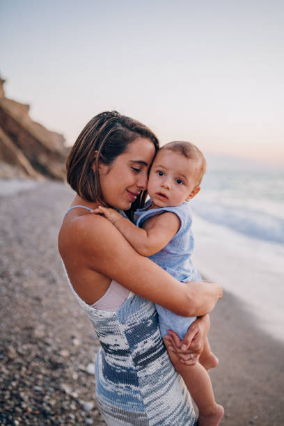 istock Mom hugs her son on the beach 1422279824