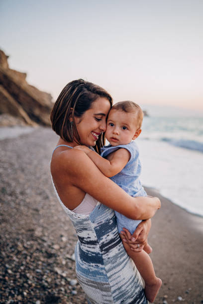 Mom hugs her son on the beach