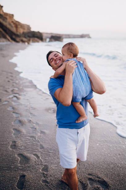 istock Dad hugs his son on the beach 1422280422