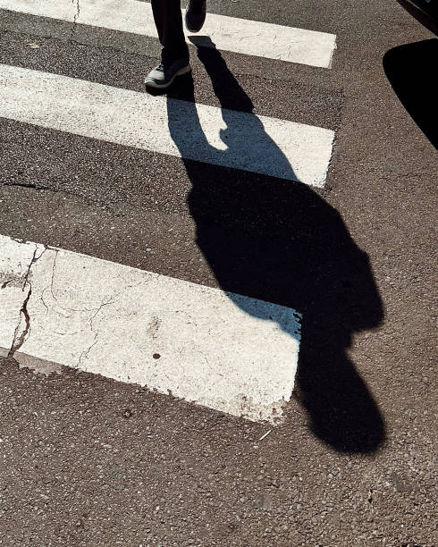 the shadow of a man on the crosswalk