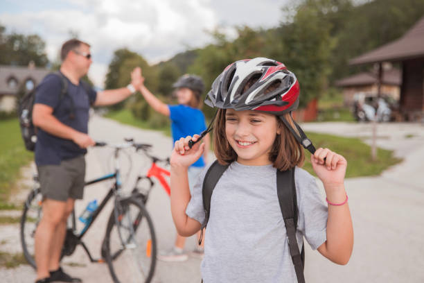 Happy young girl taking off cycling helmet after finishing cycling