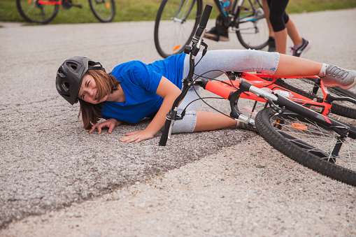 Scared young girl crying  after falling from her bike