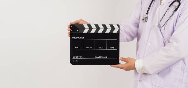 istock Doctor's holding Black Clapper board in hand on white background. Studio shooting. 1422290105