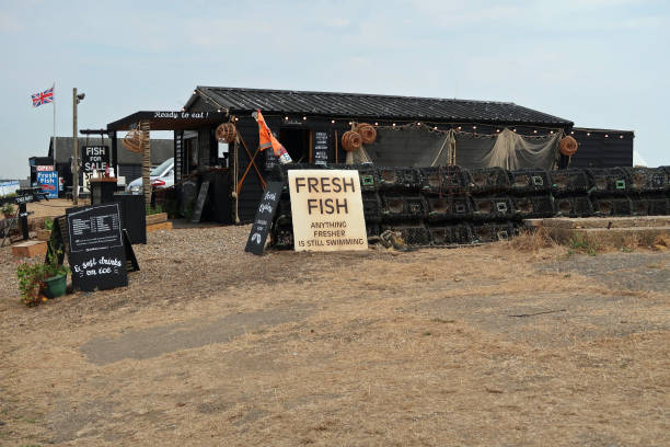 Aldeburgh, Suffolk, United Kingdom, August 16, 2022. Quaint fresh fish selling shack or shop on beach side waterfront promenade. Traditional British coastal seaside holiday resort. Summer day outdoors.