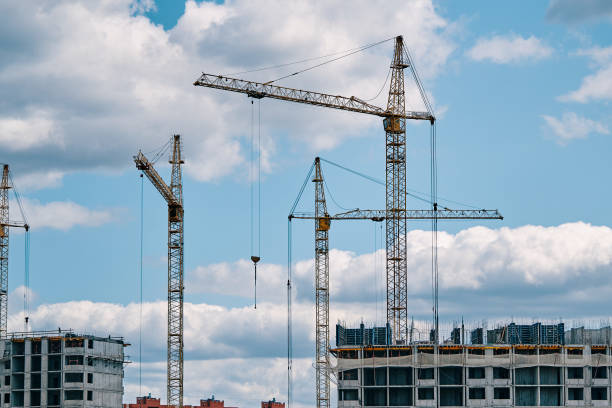 istock Construction cranes on background of cloudy sky. 1422292137