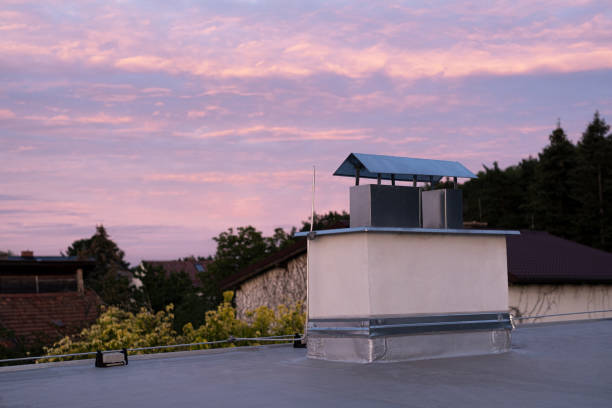 istock Flat roof covered with bitumen membrane and silver lacquer with chimney on a private house. Sunset dusk at private sector. 1422295014