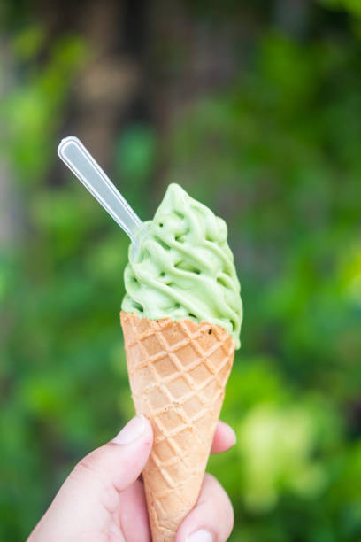 istock Hand holding green tea Matcha soft ice cream in a cone. 1422295572