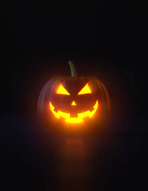 Illuminated jack o' lantern glowing over black background. Vertical composition with copy space. Halloween concept.