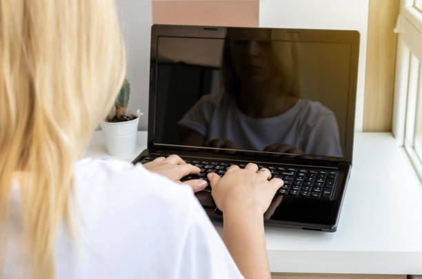 istock African girl school student e learning distance training course study work at home office. Ethnic young woman watching online education webinar using laptop. Over shoulder close up mock up screen view 1422304746