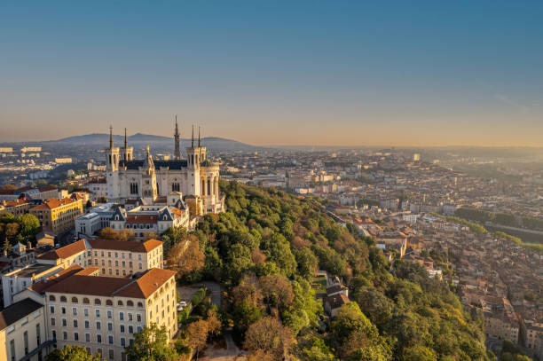 la vue aérienne par drone de la basilique notre-dame de fourvière et de la tour métallique au lever du soleil à lyon, en france. - basilique notre dame de fourvière photos et images de collection