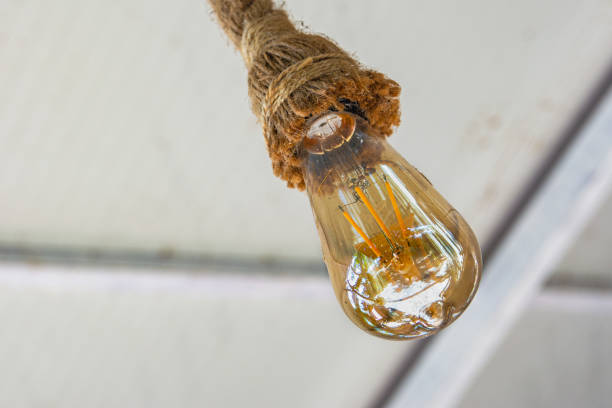 istock A vintage light bulb hangs from the ceiling on a rope. 1422314289